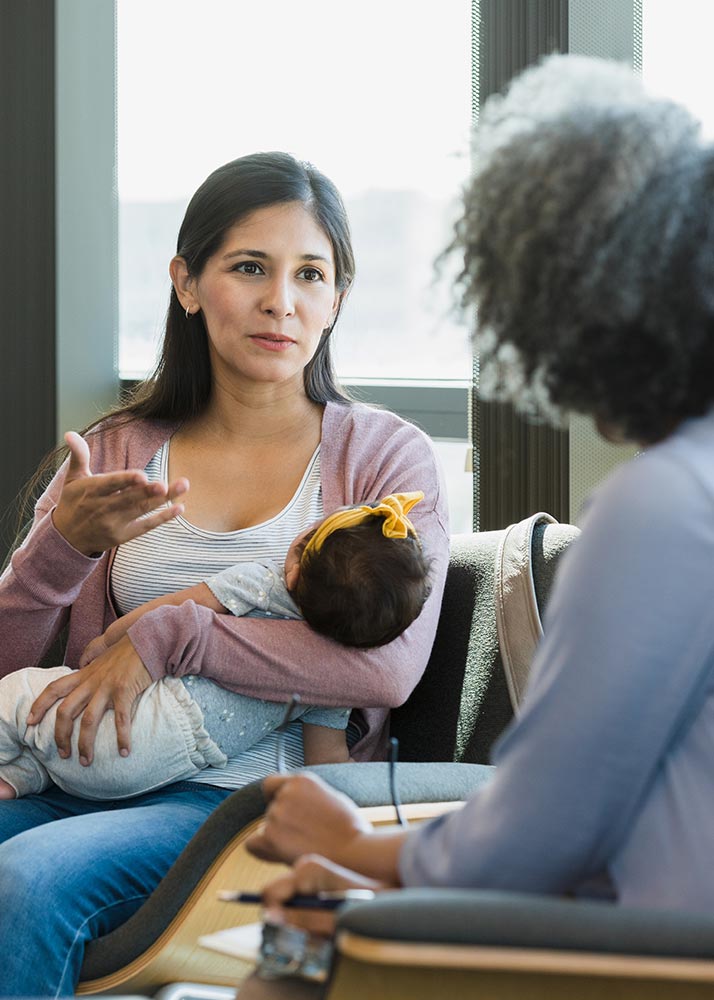 woman with newborn meeting with therapist at a group meeting